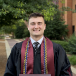 Photo of Britain Steele on graduation day in graduation robe and cords.