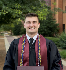 Photo of Britain Steele on graduation day in graduation robe and cords.